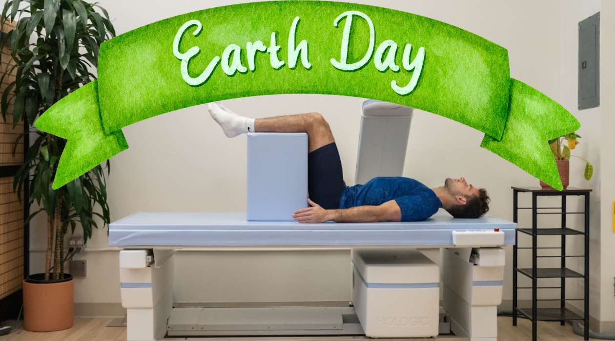 Client getting a DEXA scan with Earth Day branding in a modern clinic