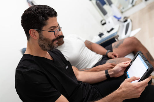 Provider reviewing DEXA scan bone density and body composition results with a GLP-1 patient on a tablet