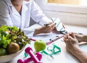 Dietician showing health metrics to salad